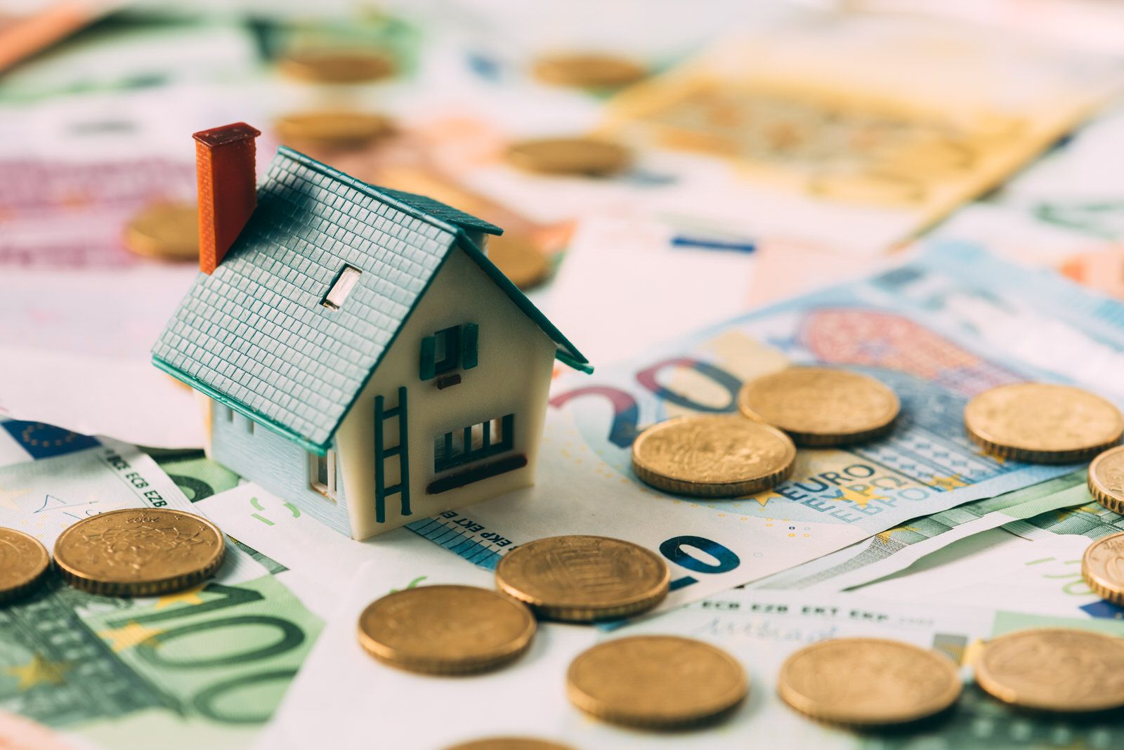 Una casa de juguete con billetes de euro simboliza las herencias y sucesiones